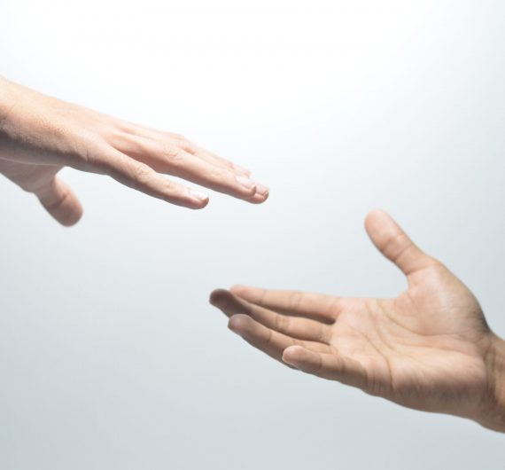 Two,Male,Hands,Reaching,Towards,Each,Other,On,Isolated,White